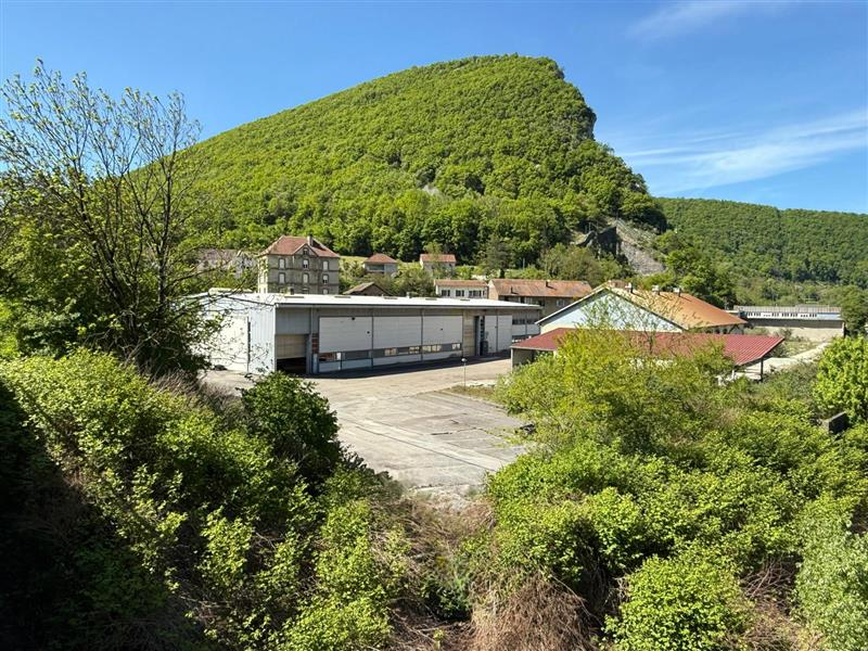 Un site industriel au pied d’un coteau boisé